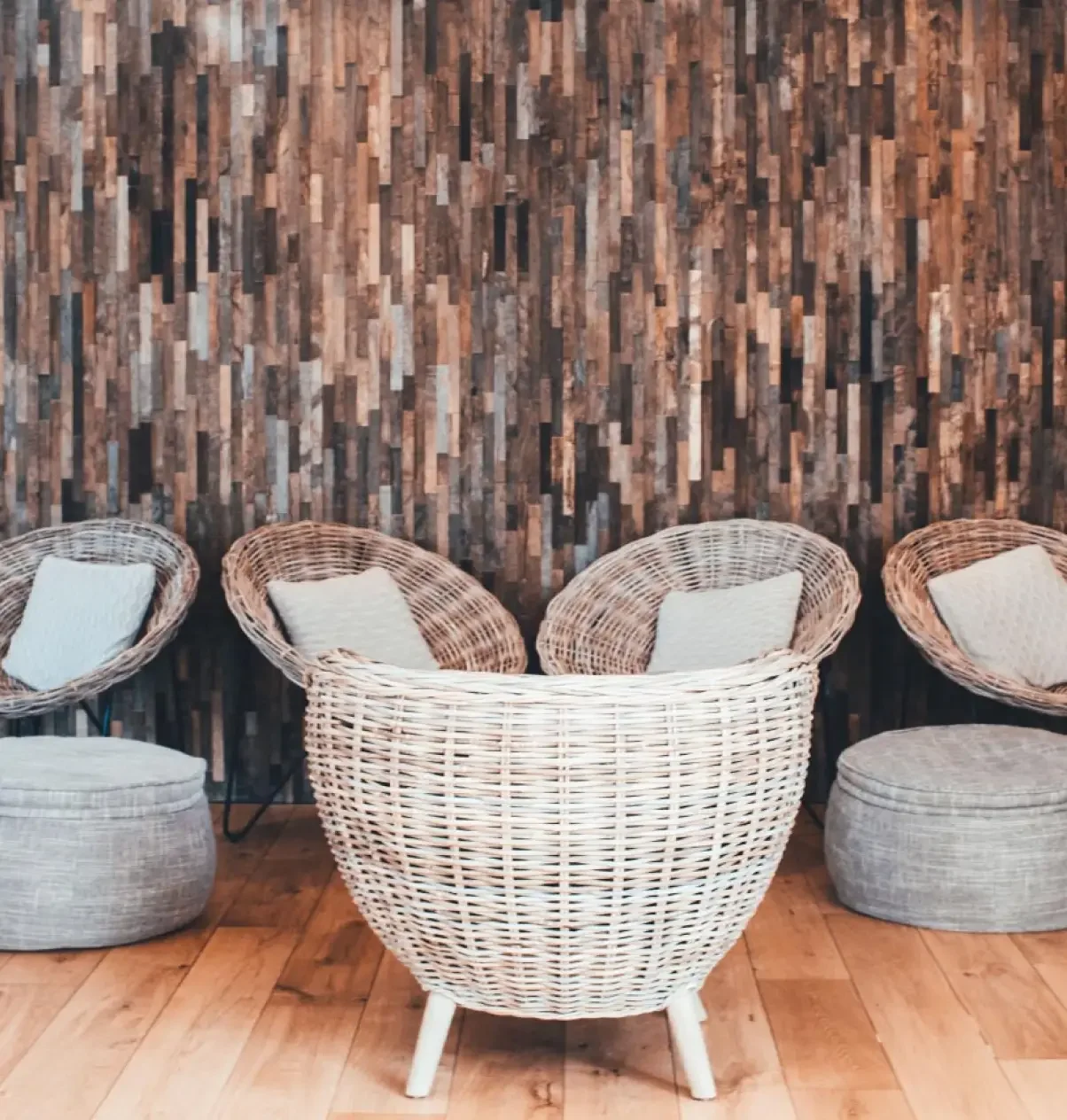 Woven lounge seating against rustic timber wall cladding at Lower Mill Estate Spa.