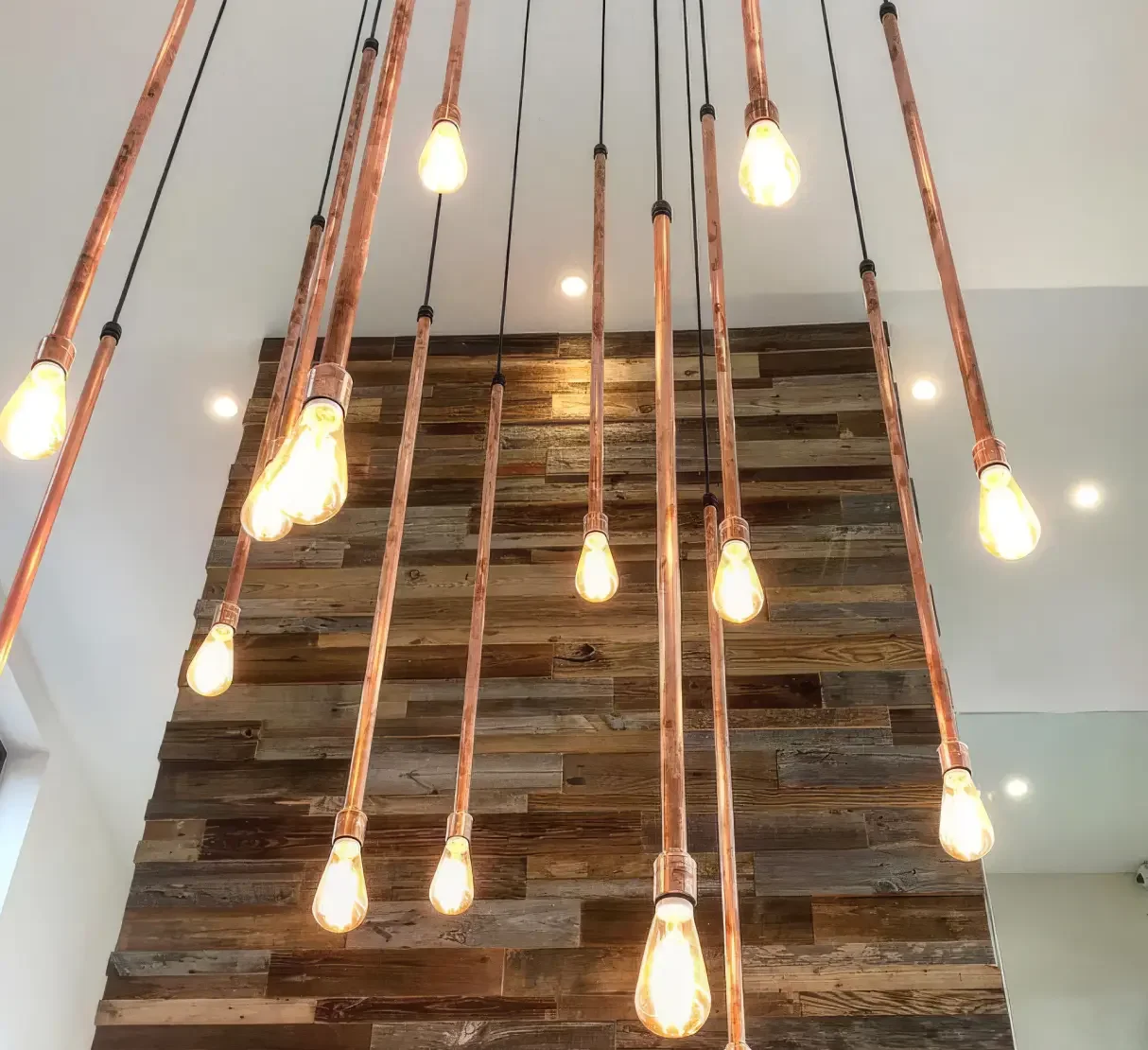 Bespoke pendant light installation made from copper pipe and exposed LED bulbs at Silverlake Hurricane Spa.