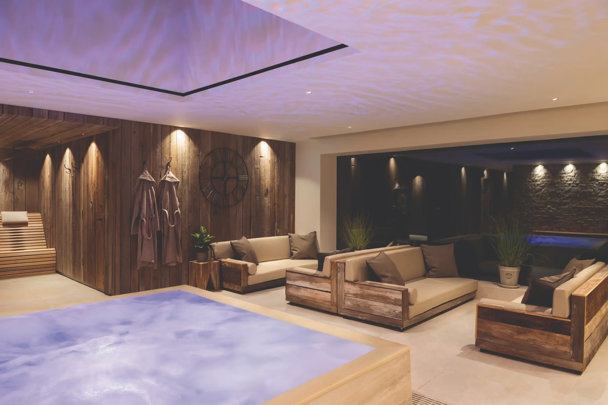 Hydrotherapy pool with integrated massage loungers and atmospheric lighting in the thermal suite at Homefield Grange.