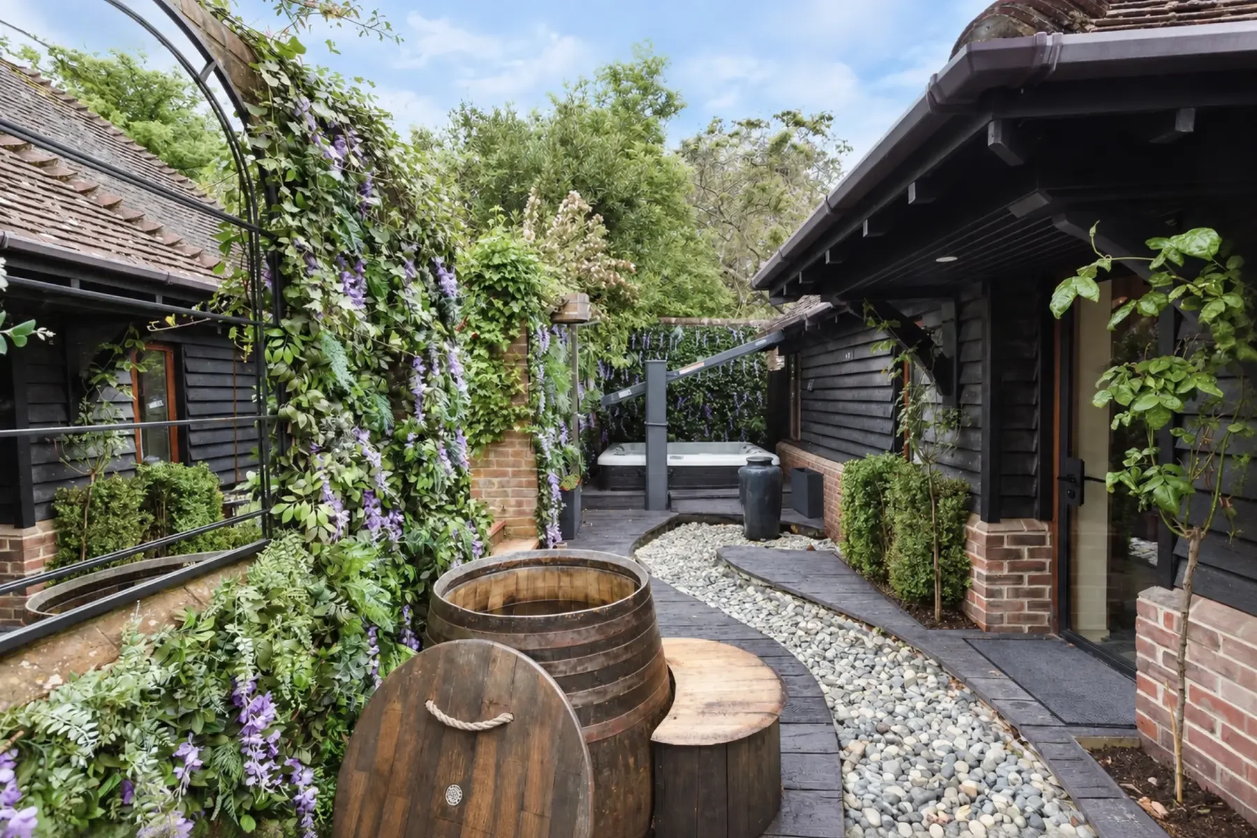 Rose Spa garden with rustic cold plunge, deluge bucket shower and hot tub.