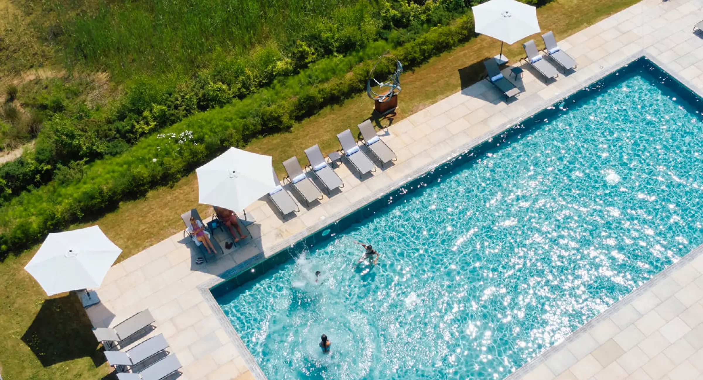 Aerial view of the swimming pool with lounge chairs and umbrellas at Silverlake Hurricane Spa in Dorset.