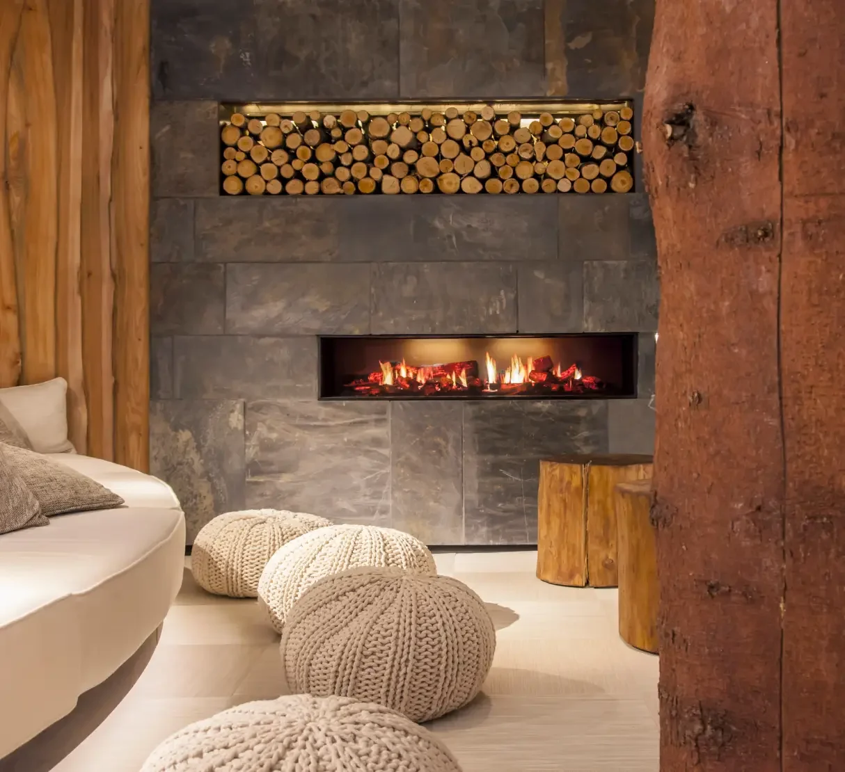 Slate fireplace with stacked logs in the Forest Mere relaxation area