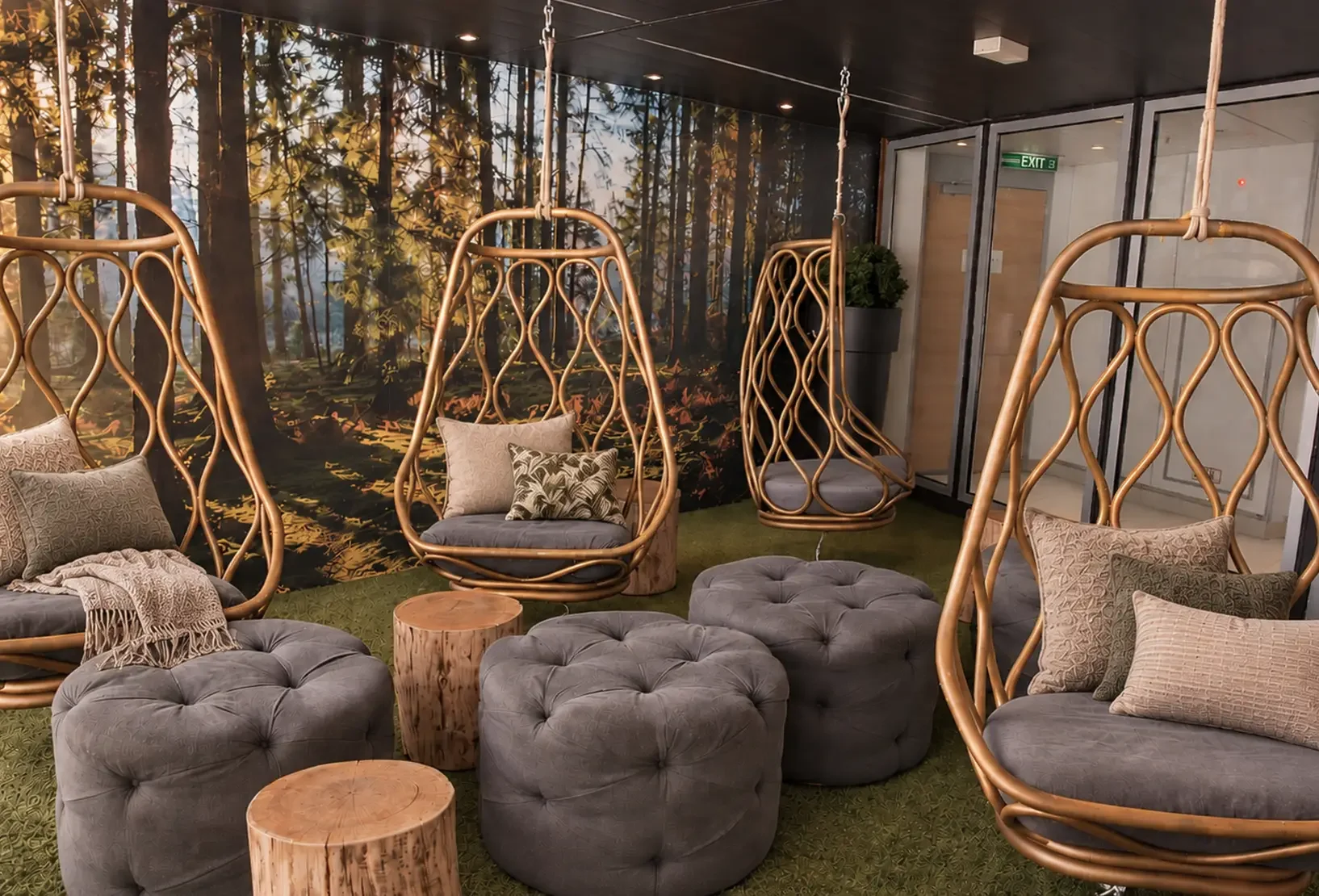 Forest-inspired relaxation room with sculptural hanging pods, natural timber tables and soft seating.