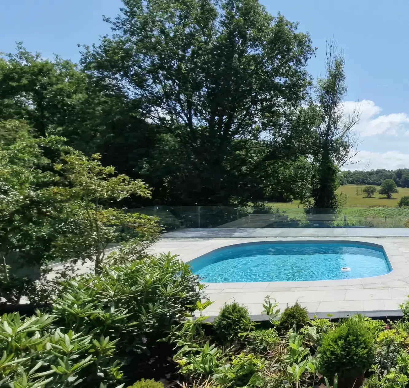 Outdoor swimming pool set within the landscape, with open views across the surrounding Hampshire countryside.
