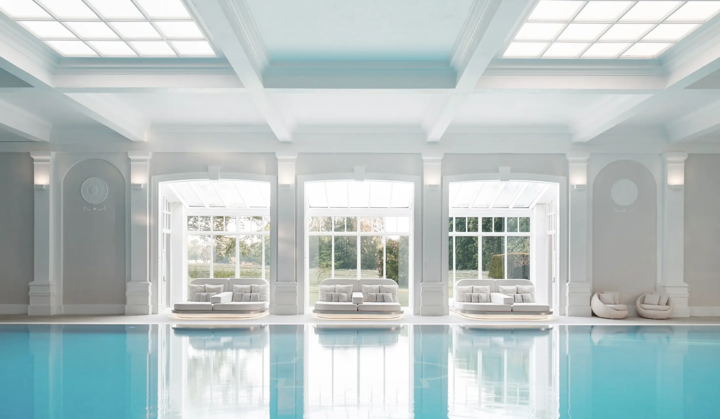 Indoor swimming pool with garden-facing relaxation bays at Champneys Henlow.