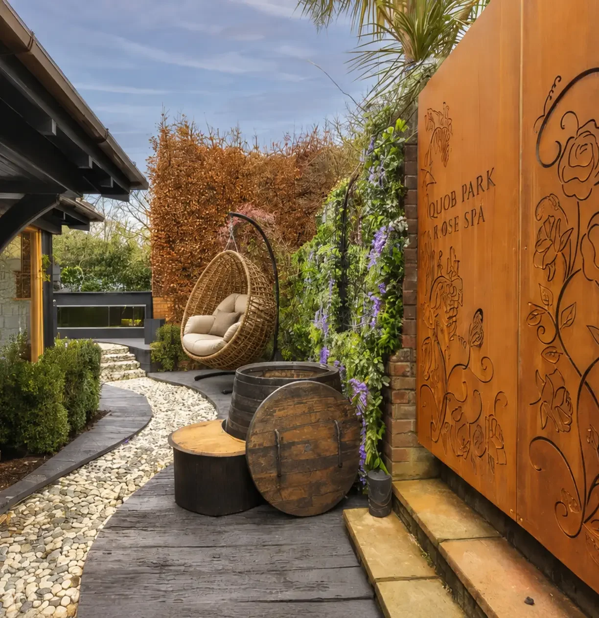 Cold plunge barrels and hanging relaxation chairs within the Rose Spa garden