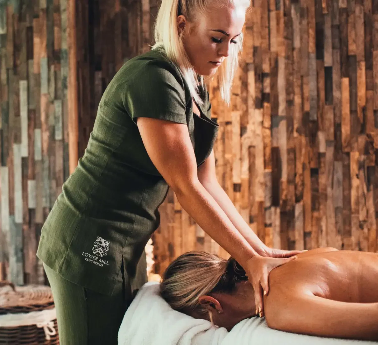 Spa treatment taking place in a warm, natural interior with rustic timber wall finishes.