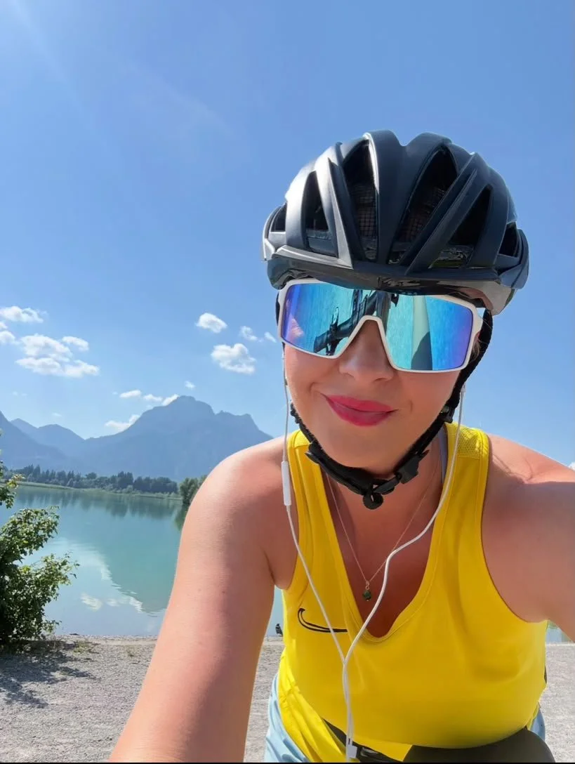 Lenka bei einer E-Bike-Tour in Füssen am Forggensee mit Schloss Neuschwanstein und Alpen im Hintergrund