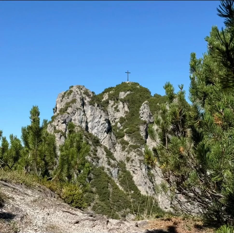 Gipfelkreuz auf einem felsigen Berggipfel bei der Wanderung zum Zunterkopf in Tirol.