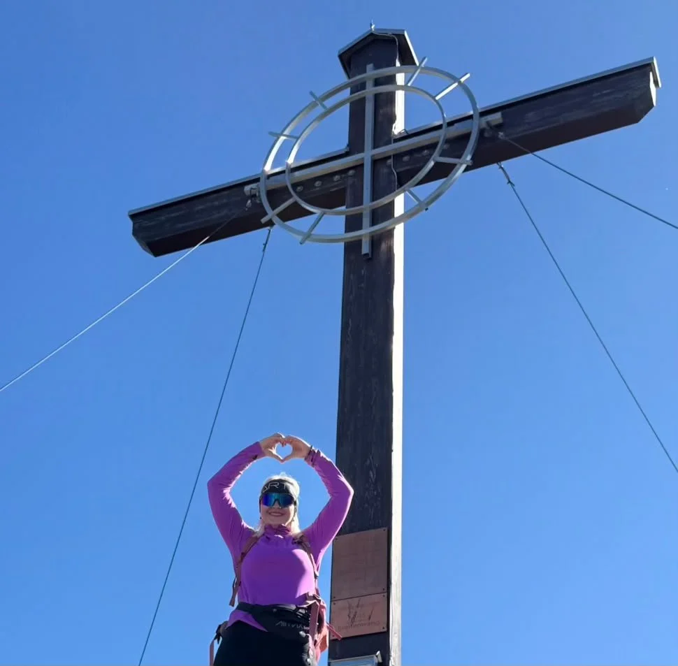 Lenka am Gipfelkreuz des Zunterkopfs auf 1.811 Metern in Tirol.