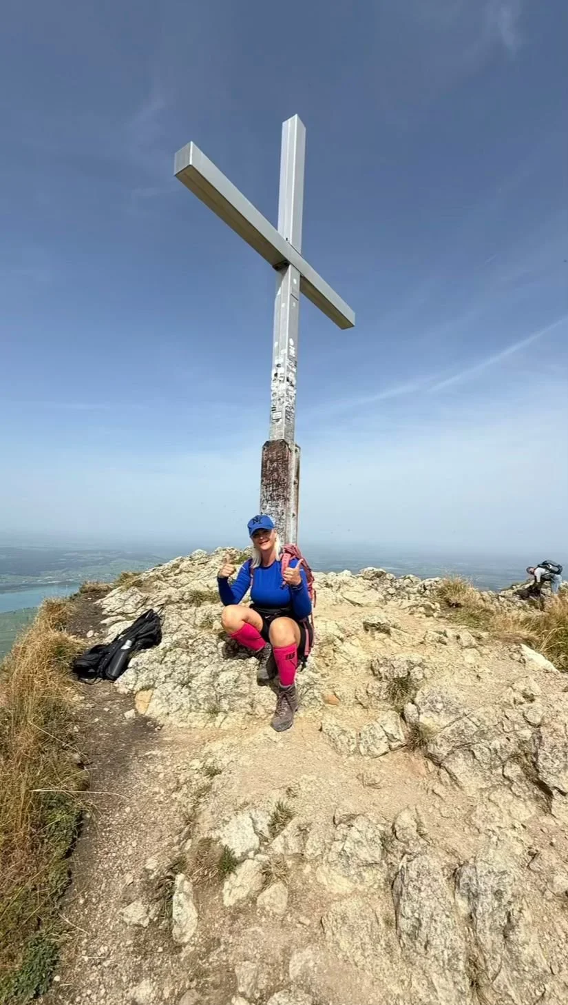 Wanderin am Gipfelkreuz des Branderschrofen auf 1.881 m am Tegelberg bei Füssen im Allgäu