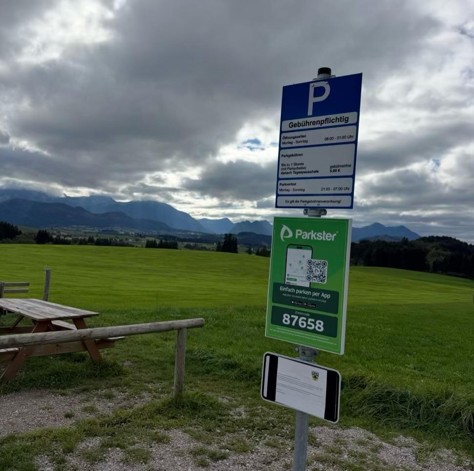 Gebührenpflichtiger Parkplatz im Hopferwald mit Blick auf die Allgäuer Berge.