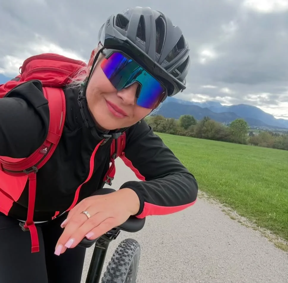 E-Bike-Tour im Ostallgäu mit Helm und rotem Rucksack vor der Allgäuer Bergkulisse.