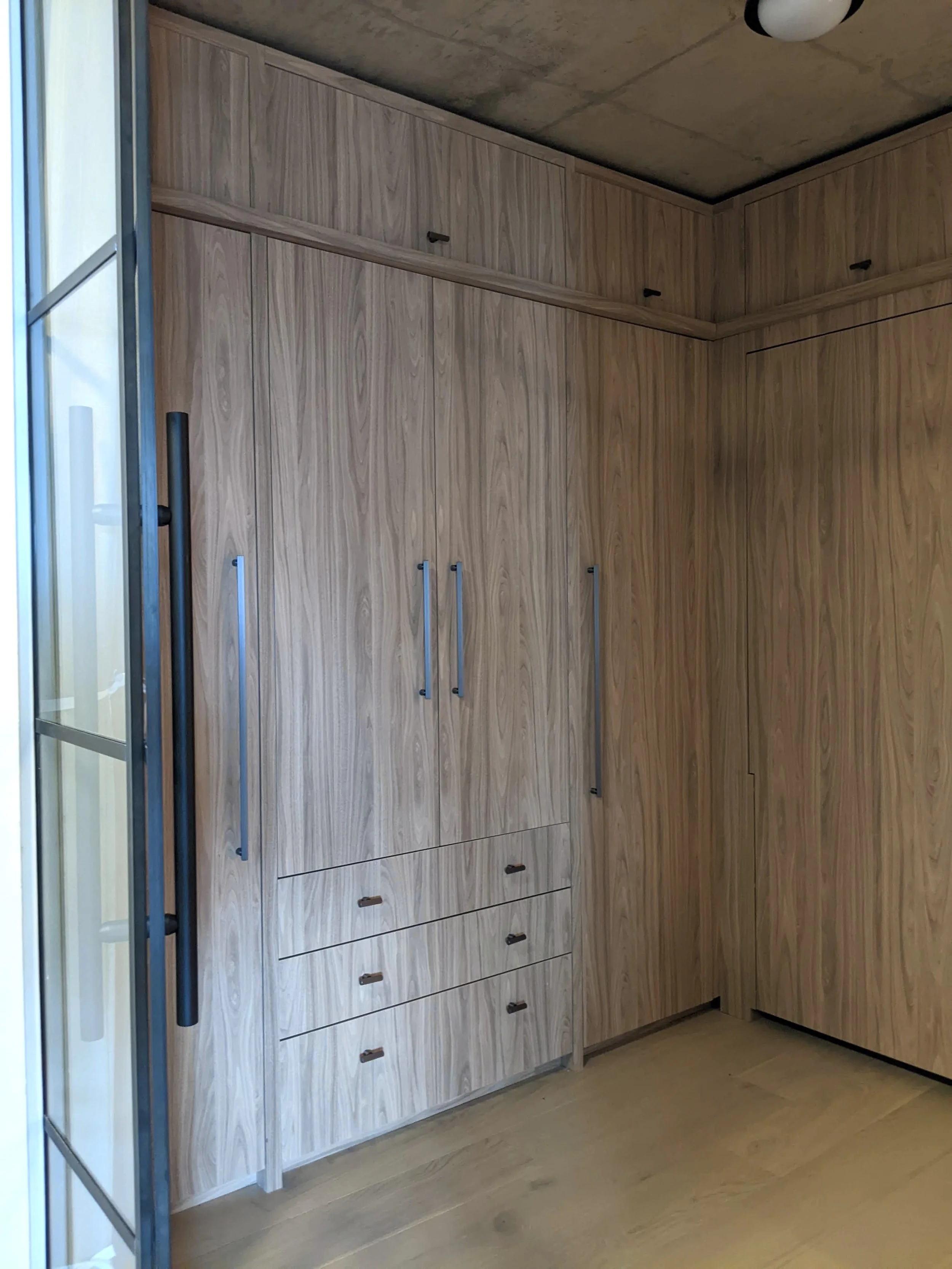 We built cabinetry that covers two full walls of the guest bedroom. We used the same high pressure laminate to match the entryway cabinets. 