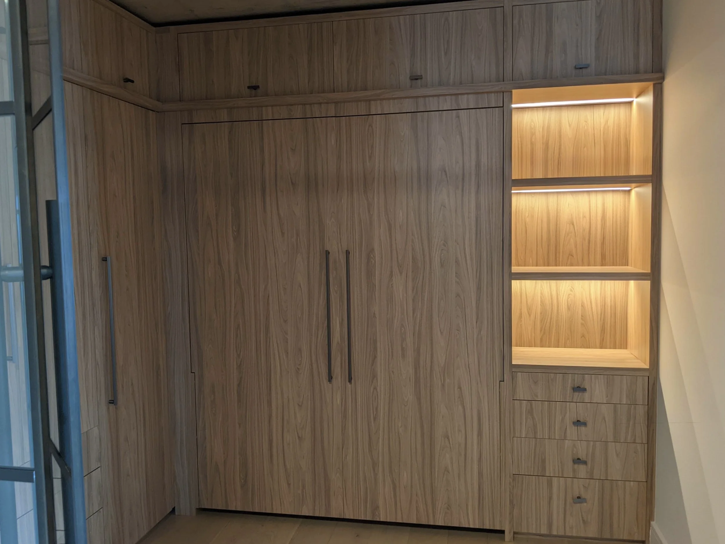 This wall of cabinets conceals a Murphy bed for guests. 