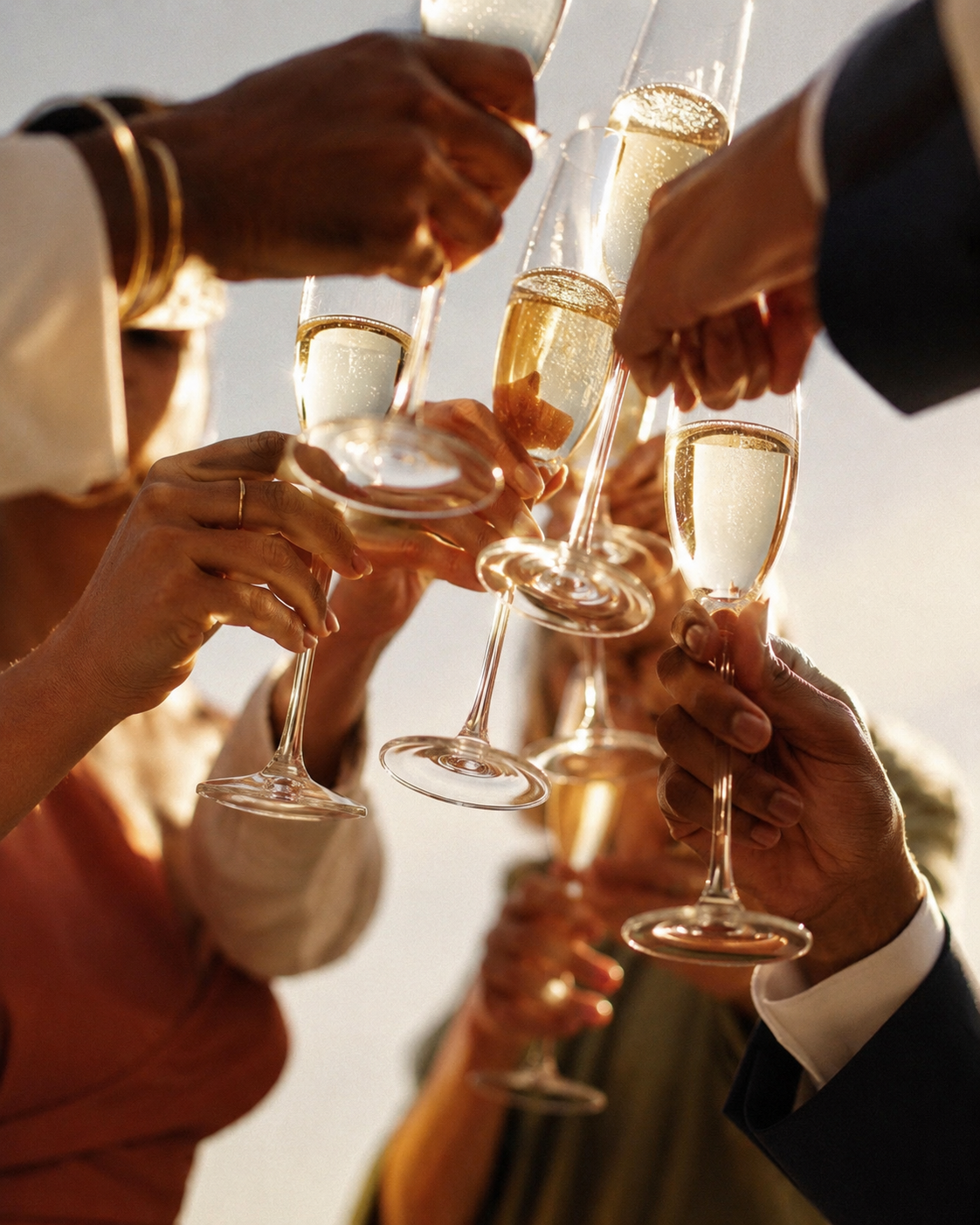 People in formal attire raise champagne glasses in a toast during celebration.