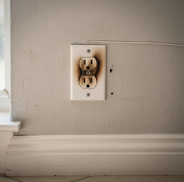 scorched wall outlet with brown discoloration around slots