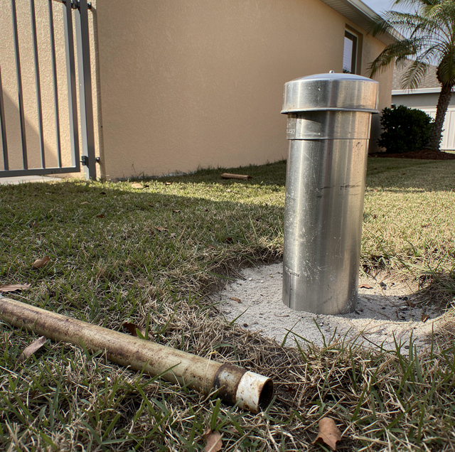 Steel well casing sealed with concrete cap in field