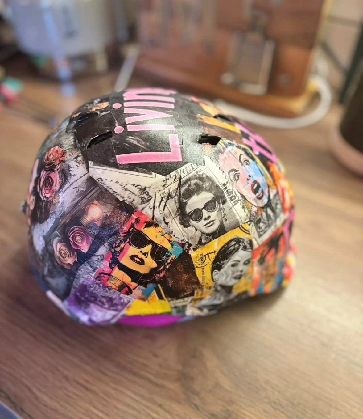 A sphere covered in collage-style pop art images, including portraits of women with sunglasses, pink roses, and colorful graphic art.
