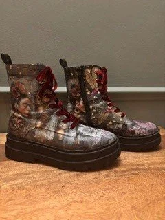Pair of Halloween-themed boots featuring images of children and pumpkins, with red laces and a black sole.