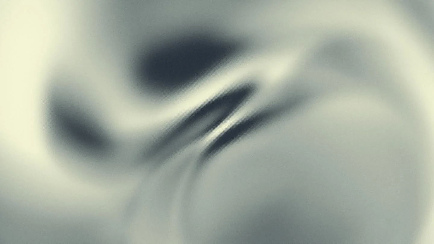 Image floue en nuances de gris avec formes abstraites.