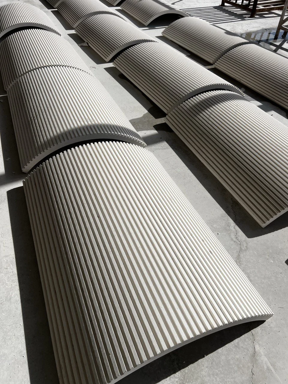 Fluted travertine cladding panels with ridged texture for architectural installation.