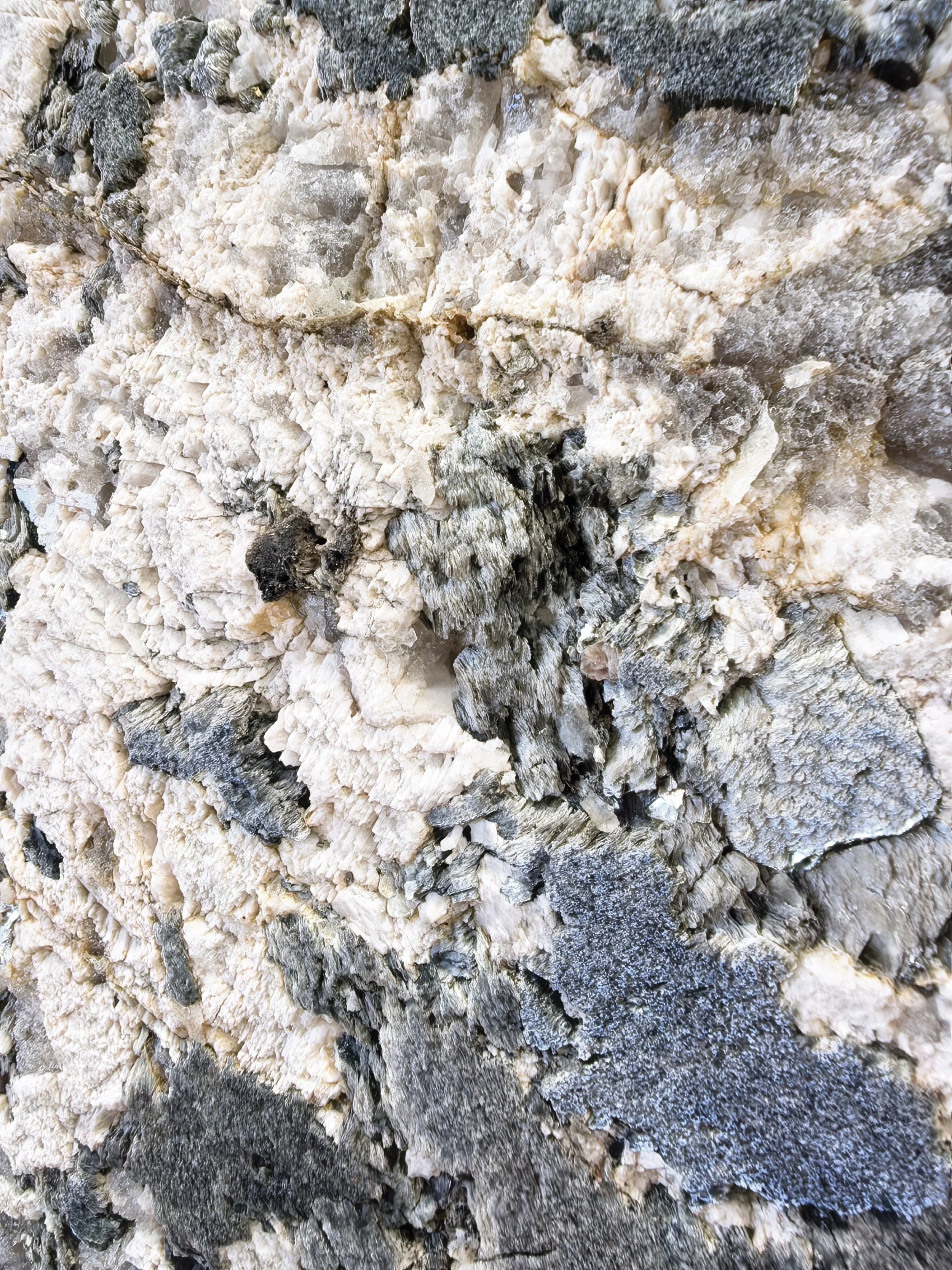 Close-up of a rough gray, black and white natural stone texture.