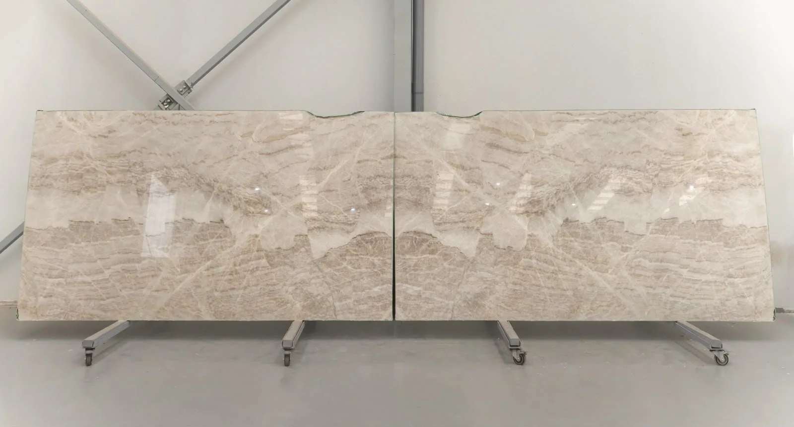 Beige travertine slab being handled at the G STONE factory