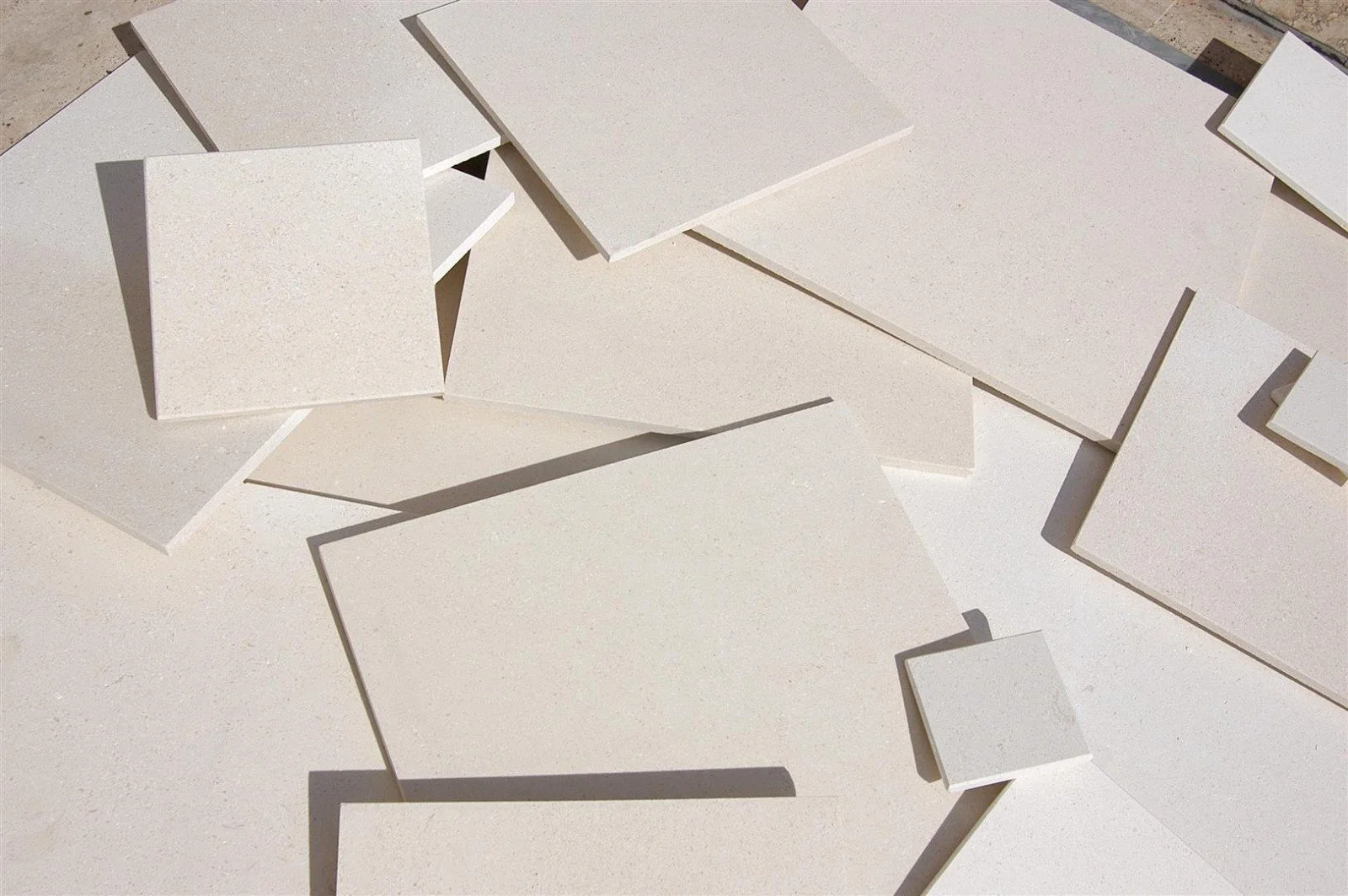 Several white stone tiles of different sizes arranged and overlapping.