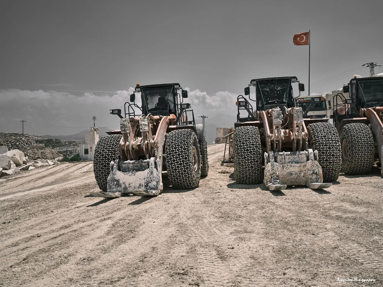 Heavy earth-moving machinery parked at a stone quarry site in Türkiye.