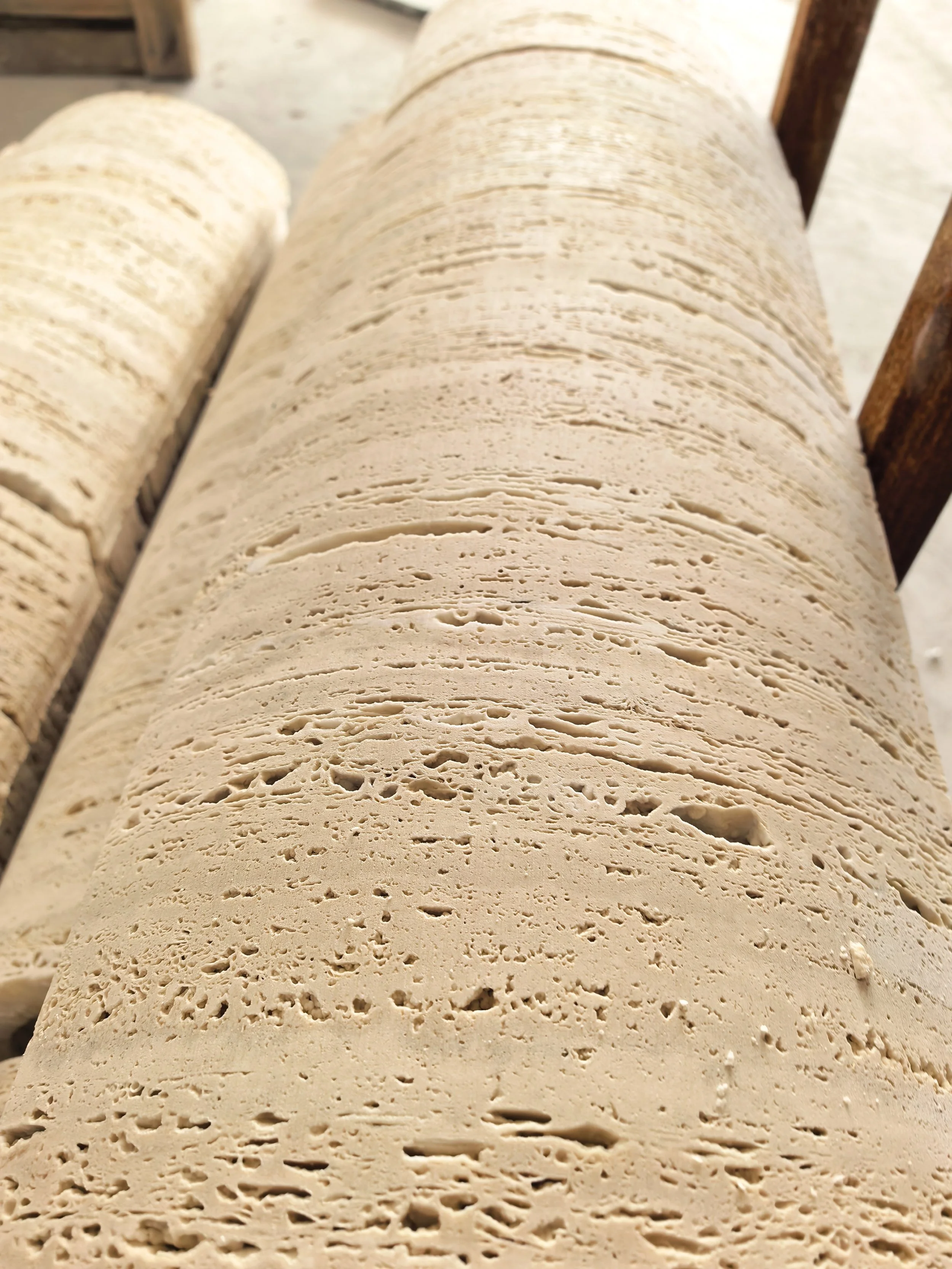 Close-up of a rolled beige textured material on a wooden surface.