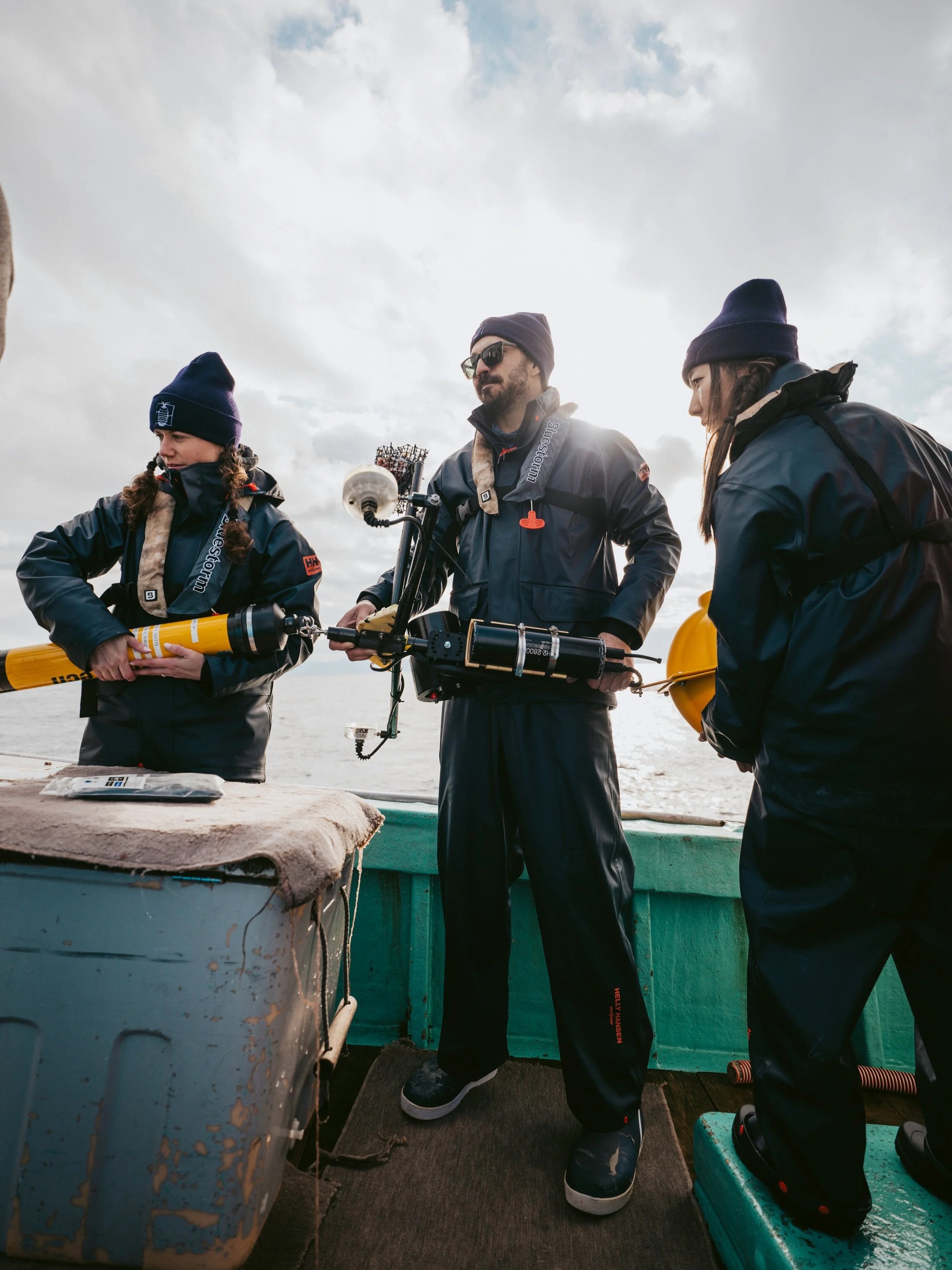 Shannon Aldridge, Dr. Austin Gallagher, and Ayumi Kuramae deploying a Deep-Sea Baited Remote Underwater Video System (dBRUVS).