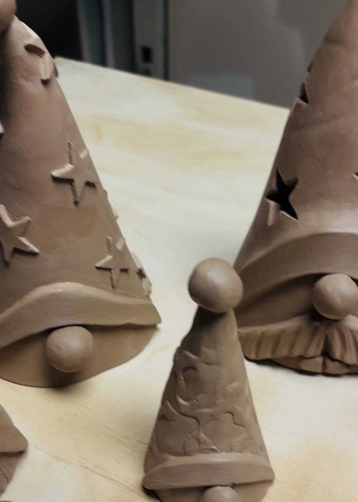 Unfinished ceramic Christmas gnome figurine with a tall, pointed hat decorated with star cutouts and large round nose.