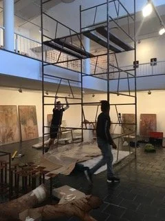 Installeren van een tentoonstelling in de AVA Gallery, Kaapstad, met behulp van een steiger