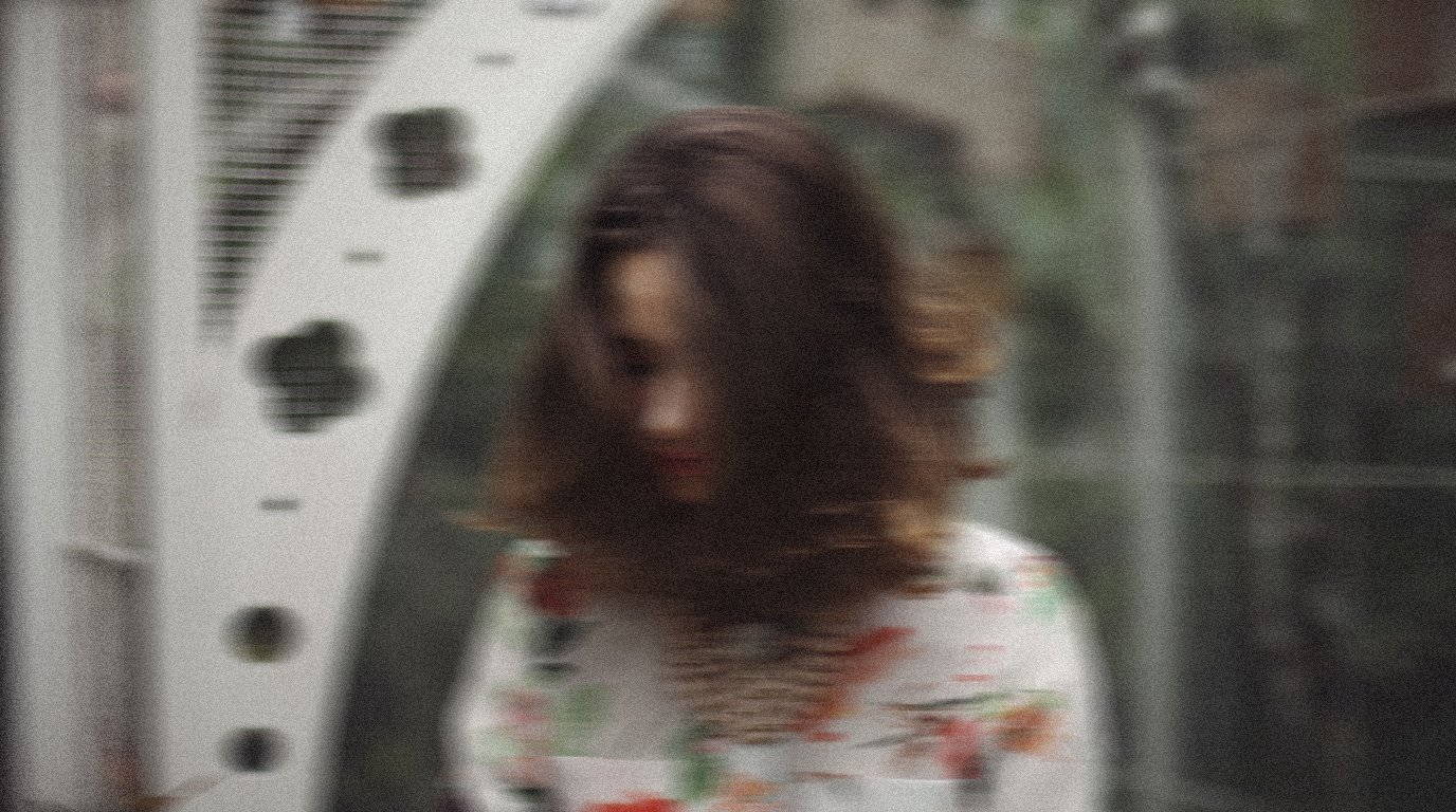 Fashion portrait photography by Pigalle Production, Seoul, of a woman with brown hair against a metallic architectural structure.