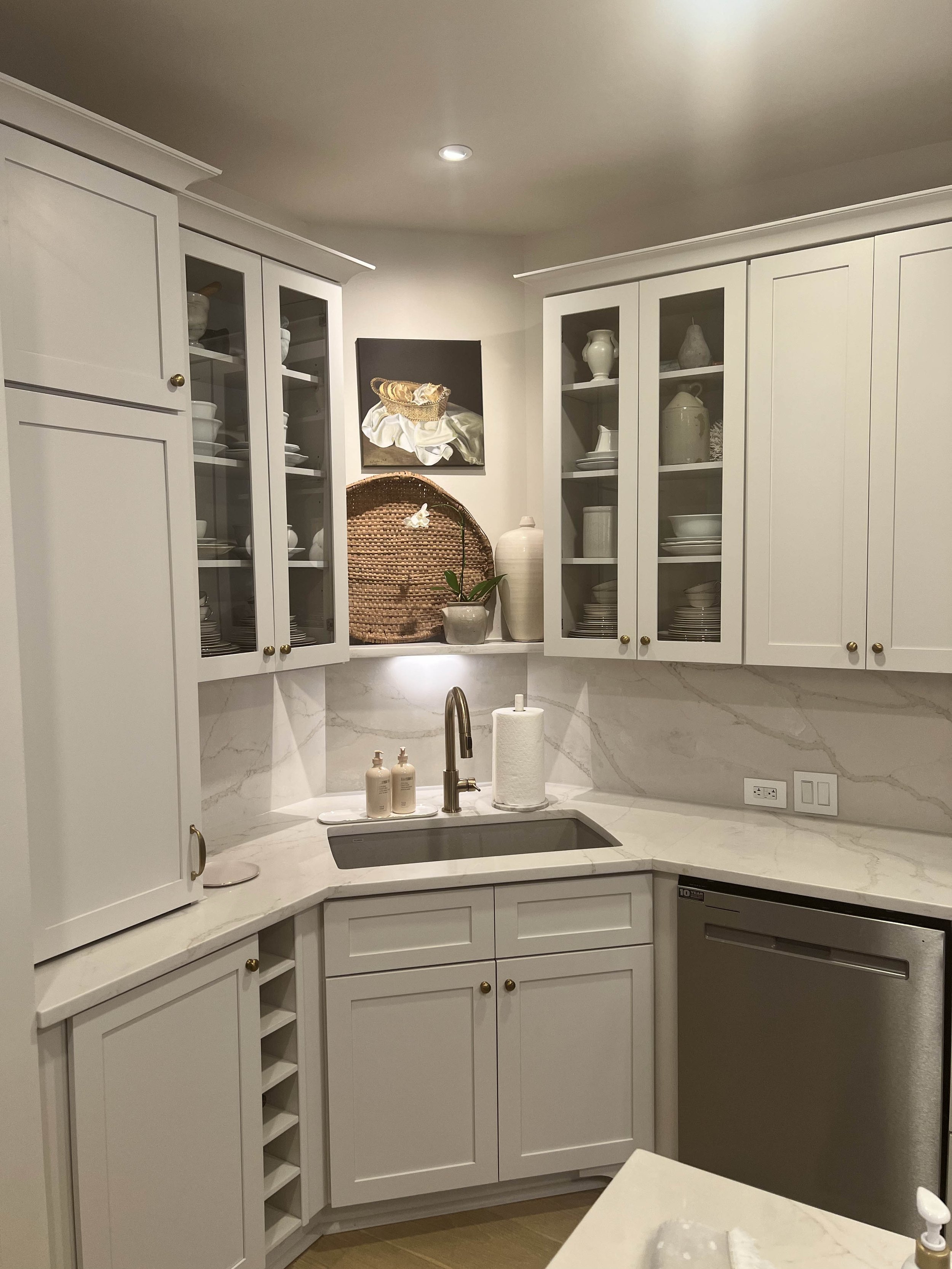 Custom kitchen cabinetry with glass-front cabinets and quartz countertops