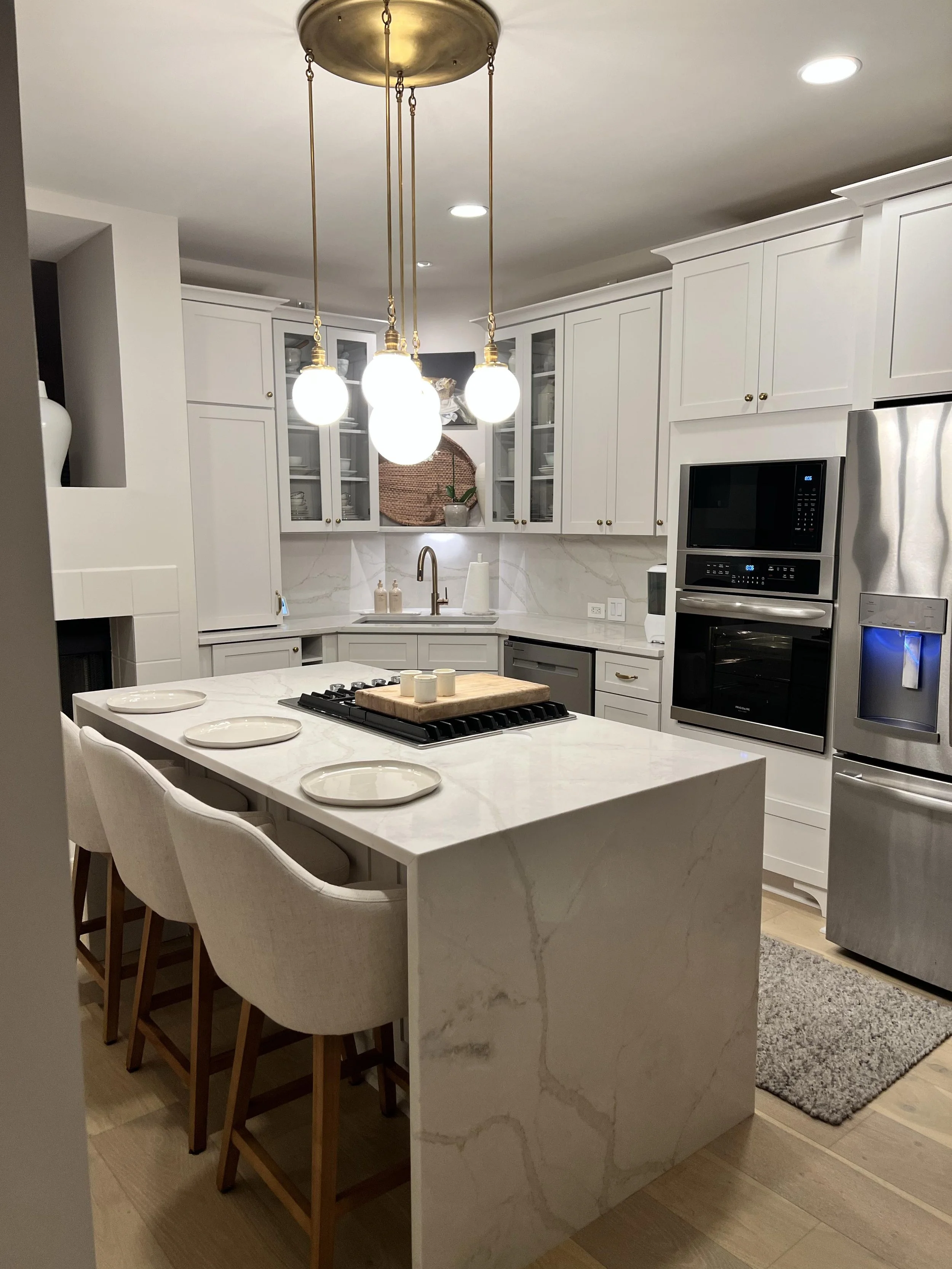 Kitchen remodel with white cabinetry, waterfall island, quartz countertops, upgraded appliances