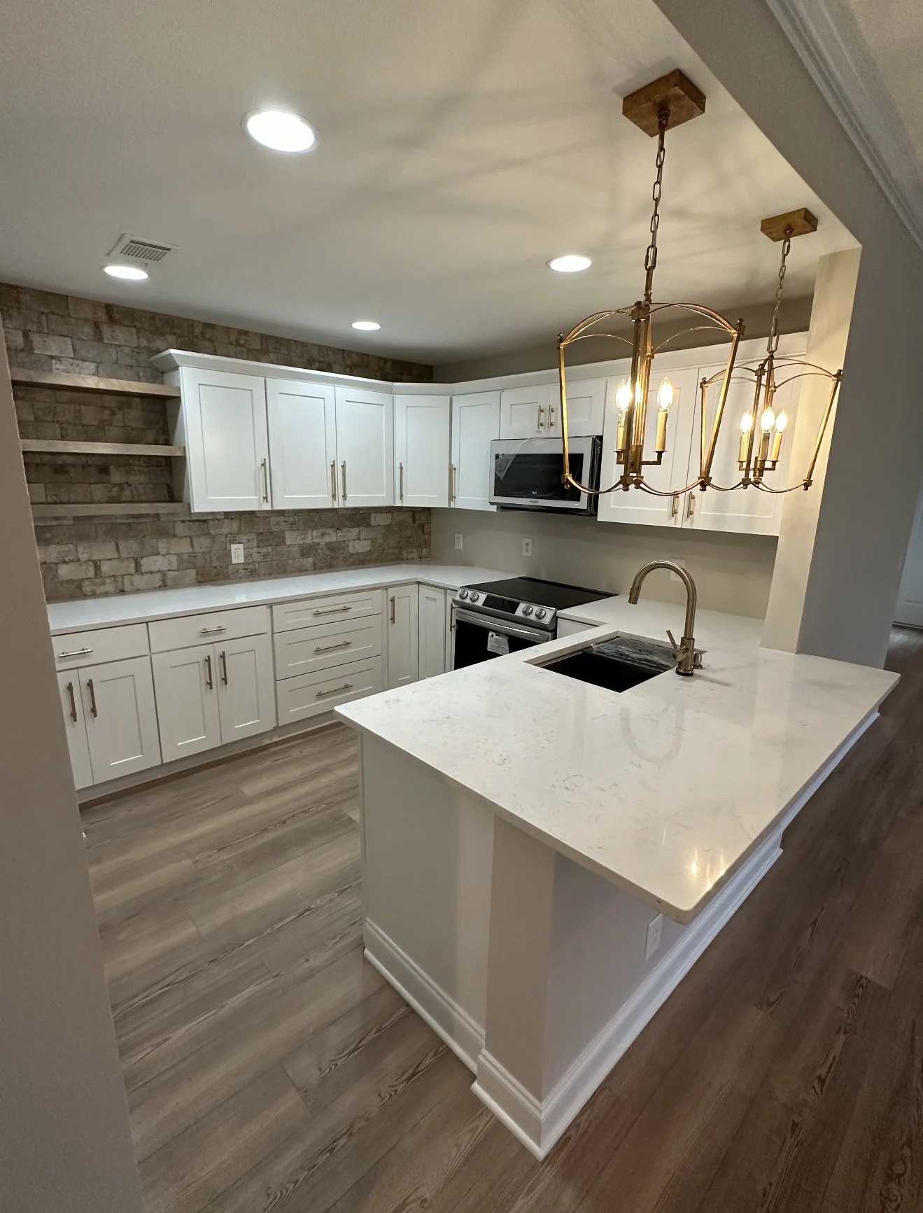 Kitchen remodel with white cabinetry, custom wood shelving, custom stone backsplash