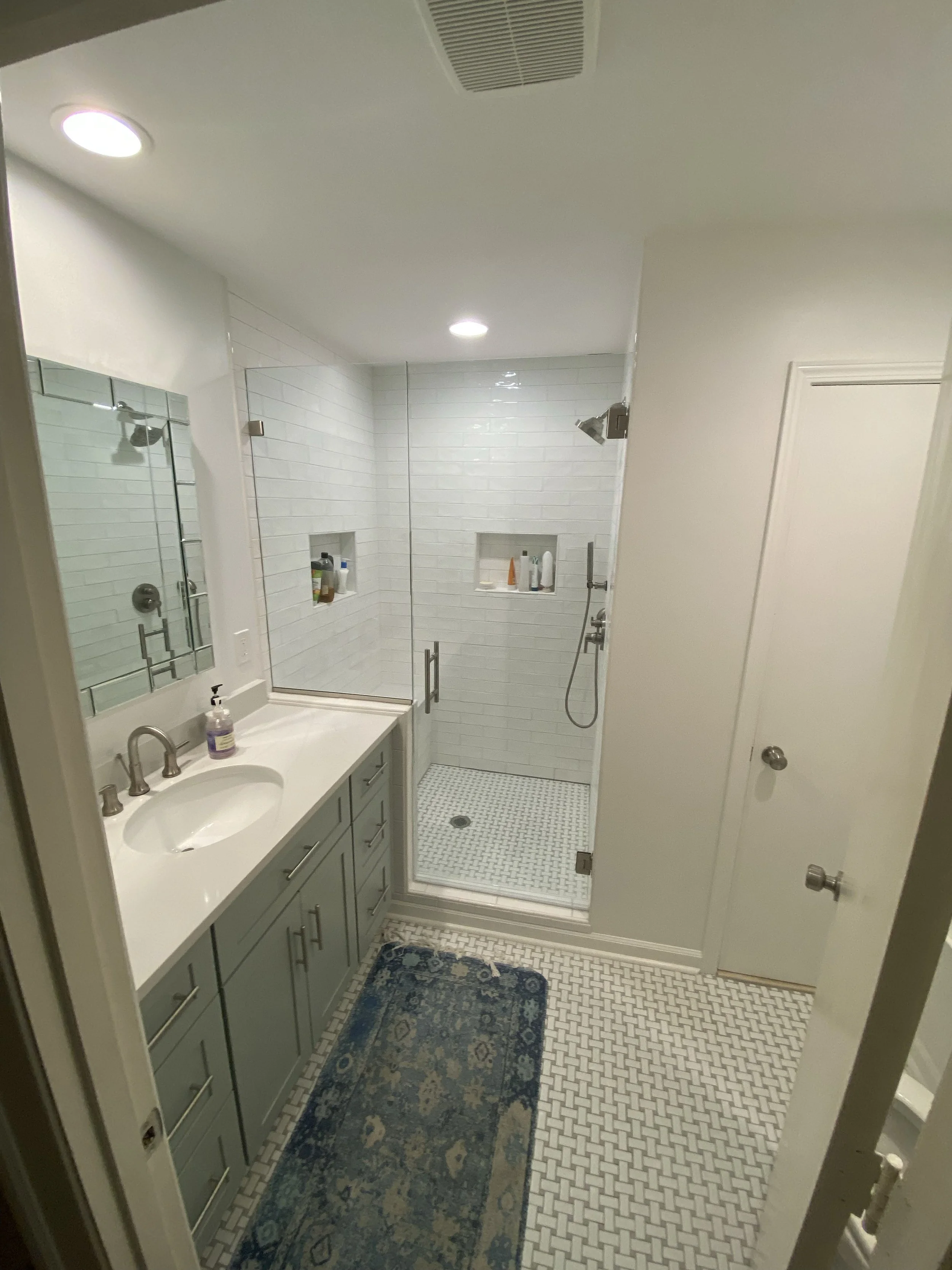 Bathroom remodel with gray vanity, tile flooring and glass walk-in shower