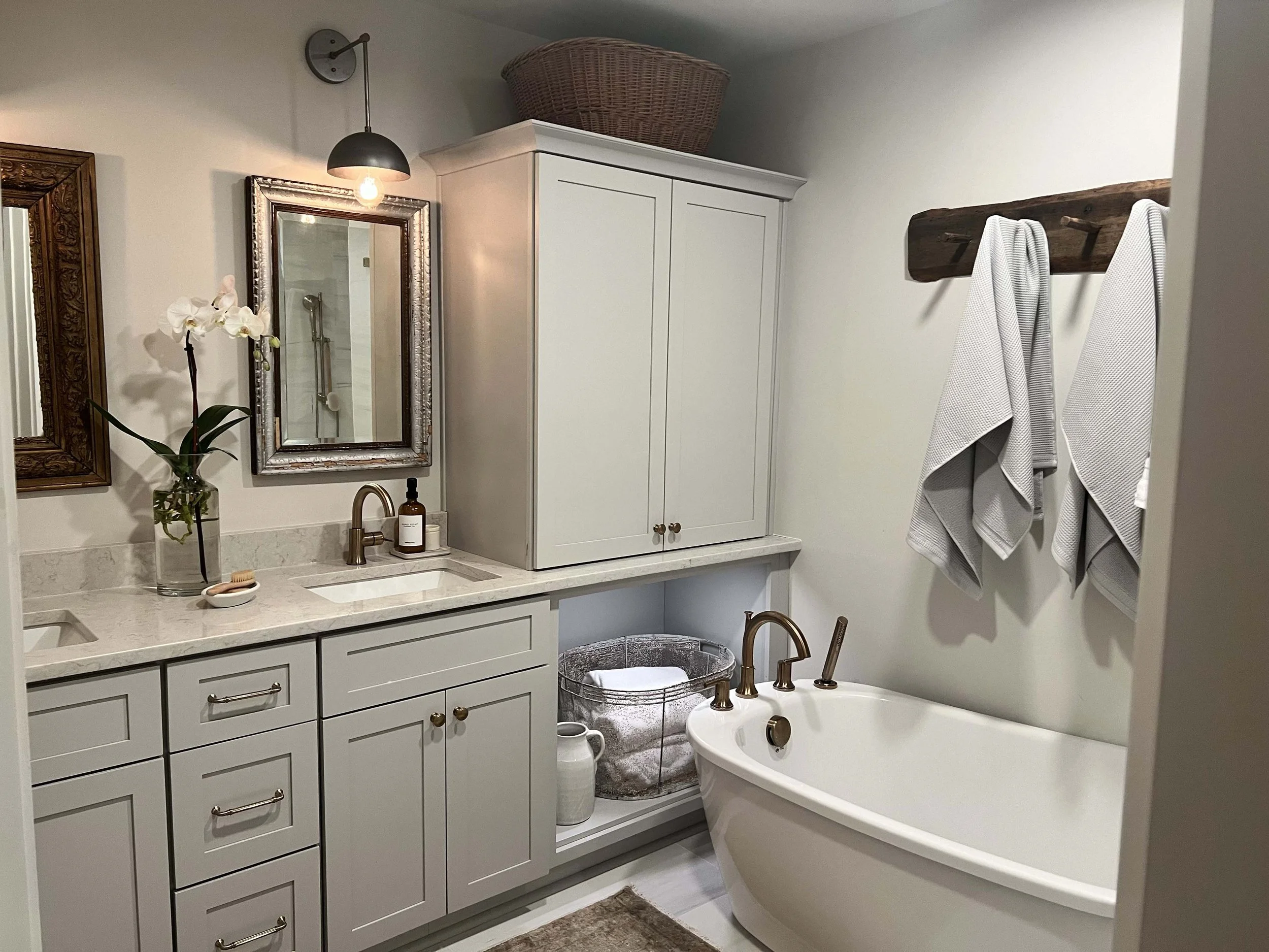 Bathroom remodel with custom white vanity and freestanding soaking tub