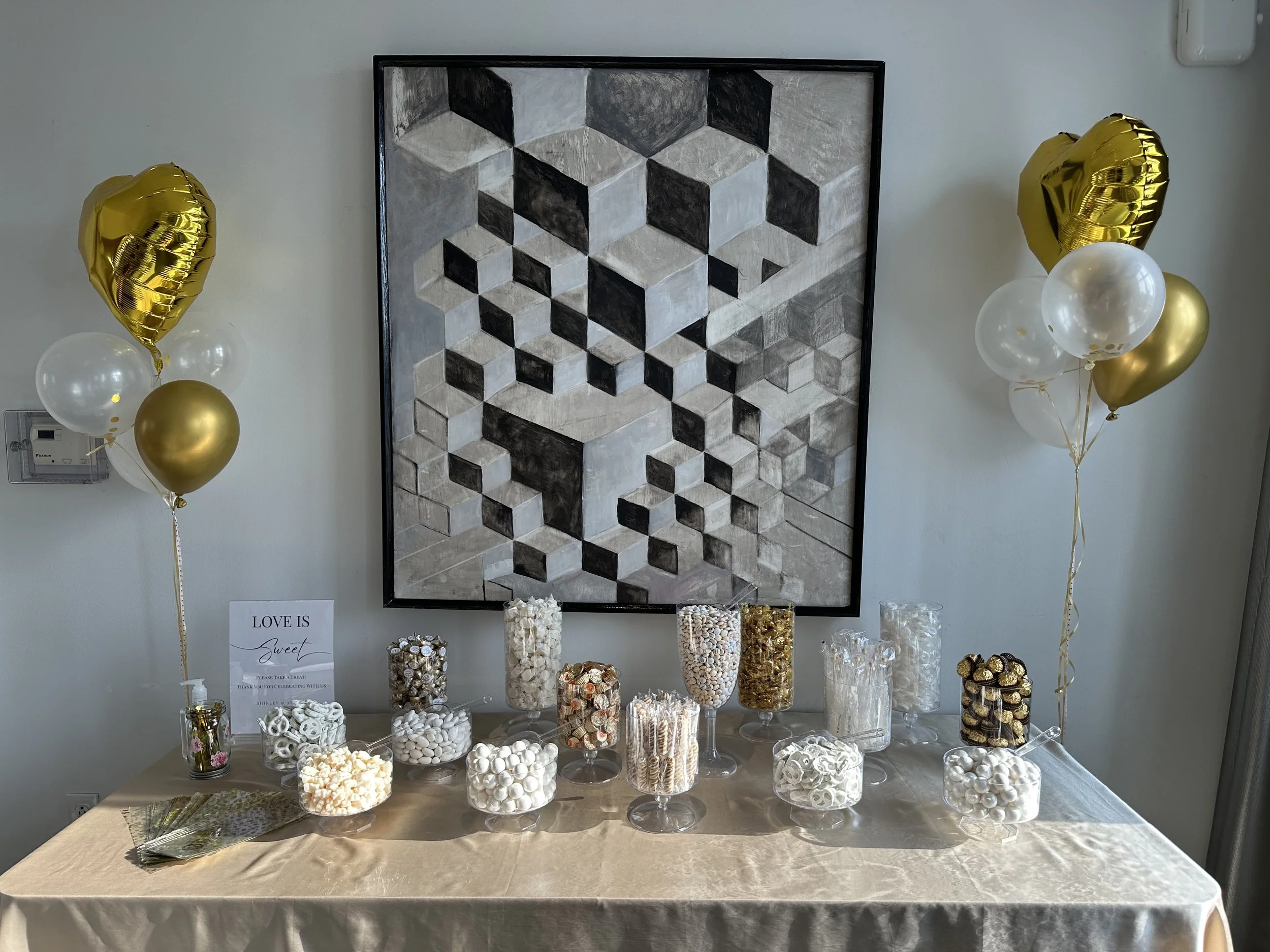Elegant gold and white candy bar in decorative candy jars for engagement party favors