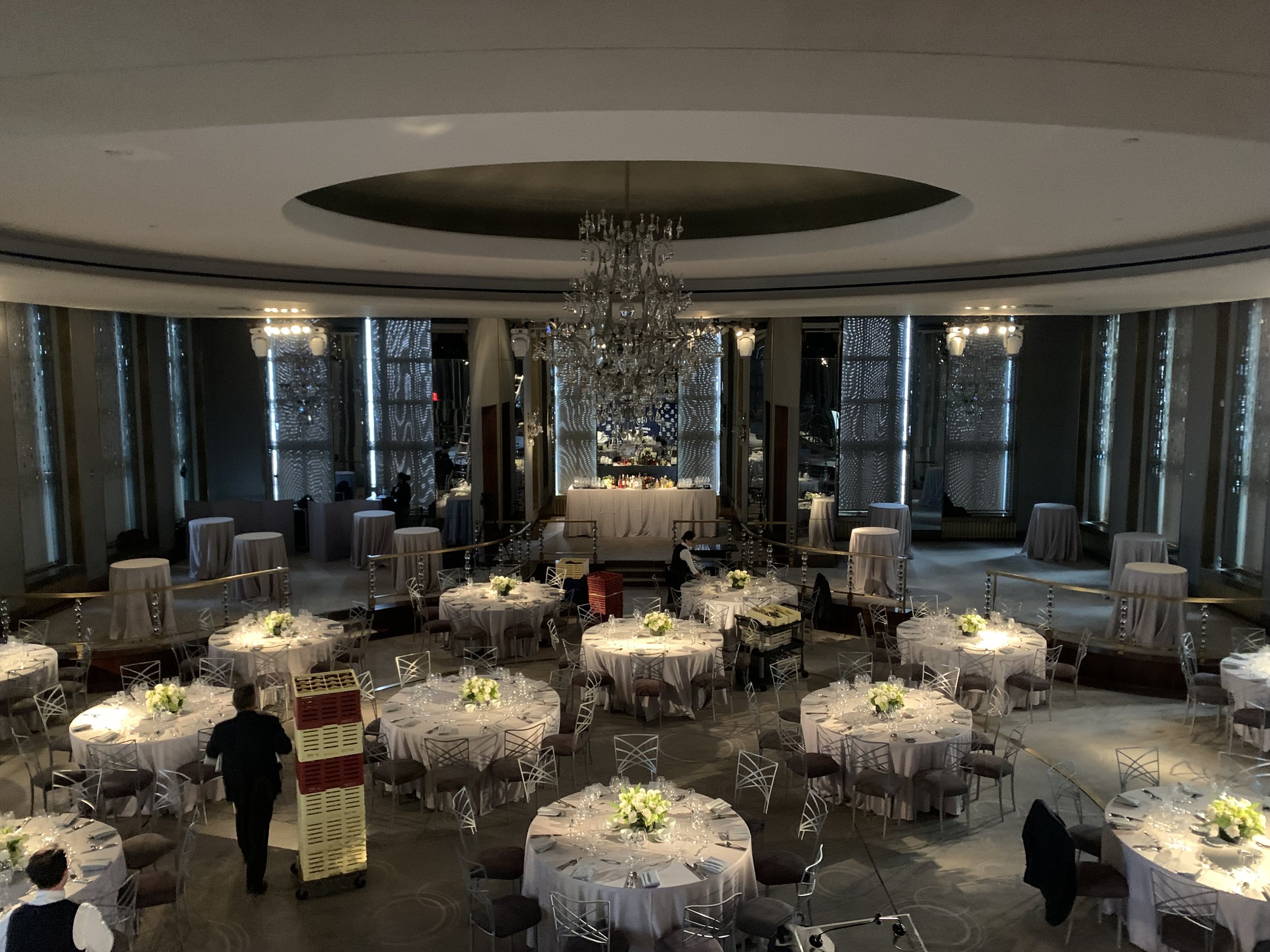 The Rainbow Room in New York City. There are staff members setting up the tables.