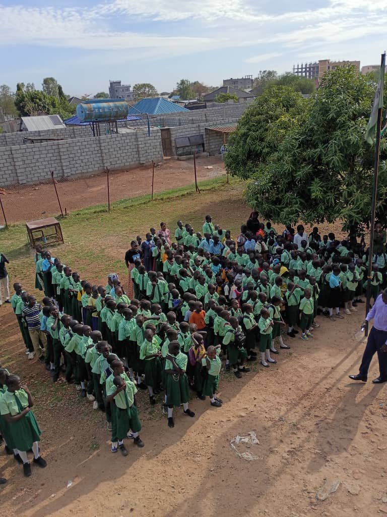 Group of students in uniform standing outdoors in a schoolyard