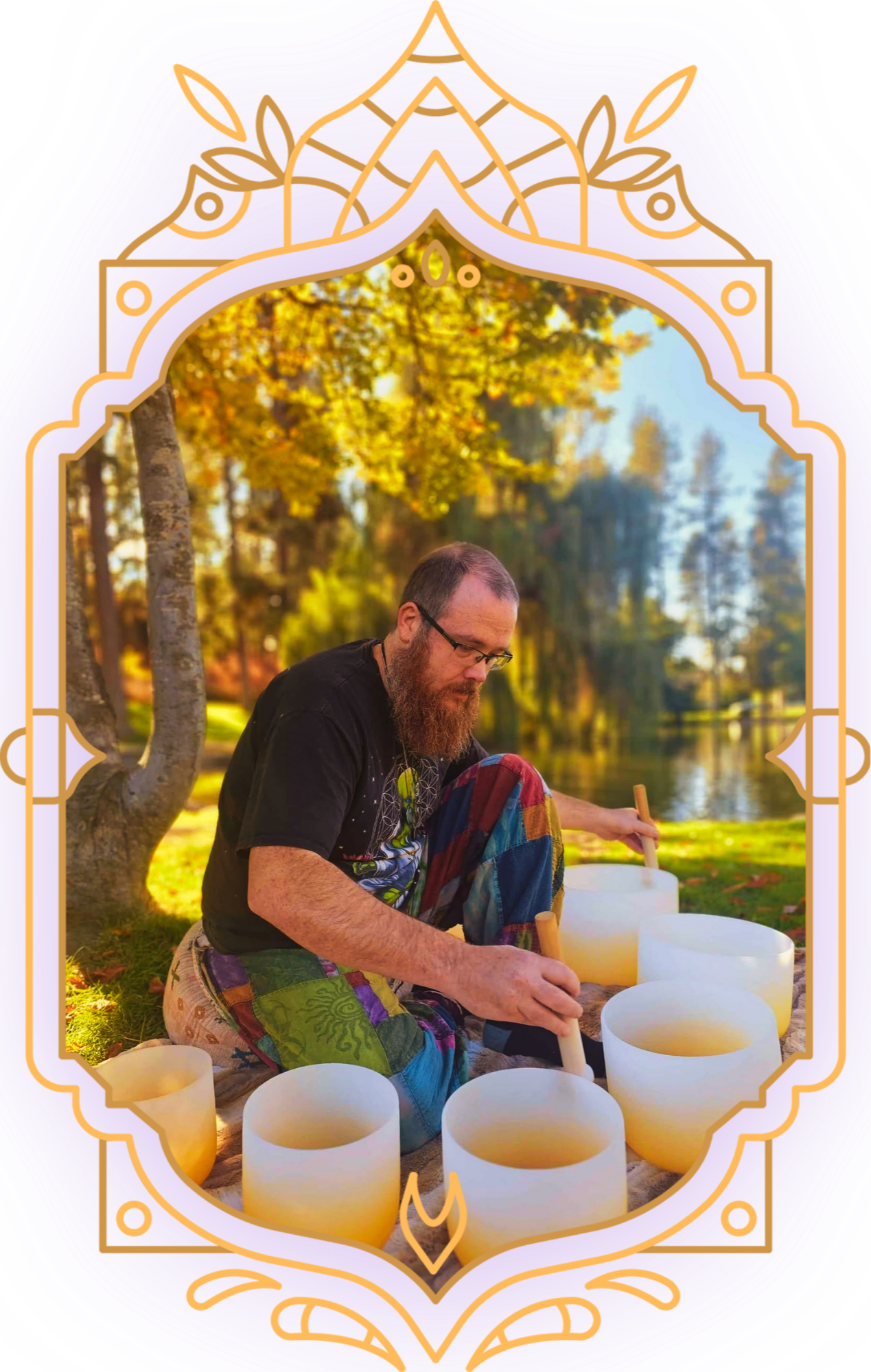 A man with a beard and glasses playing a wooden hand drum outdoors during daytime, surrounded by large white bowls, with trees and cloudy sky in the background, framed by an ornate purple and gold border.