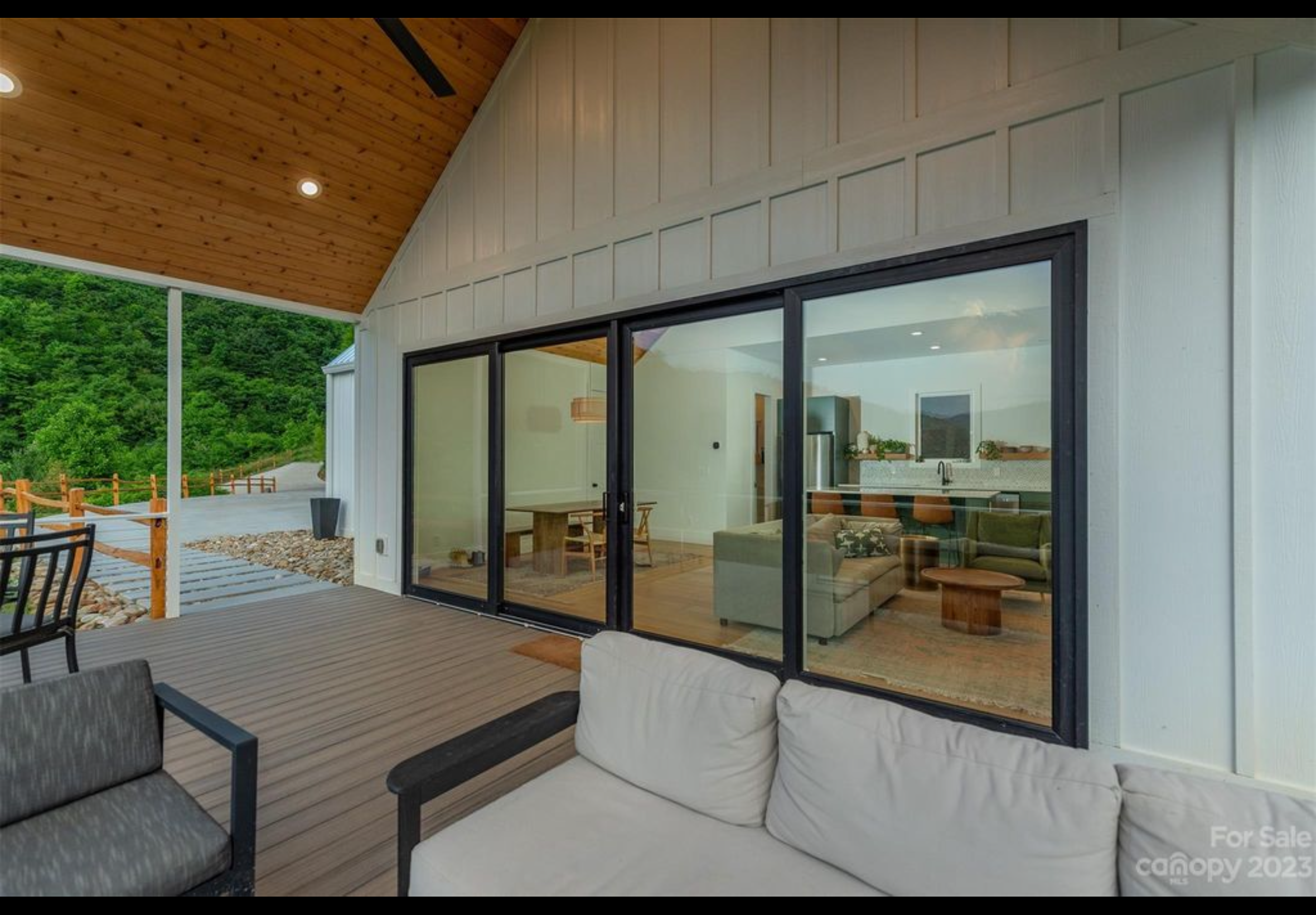 Finished front porch deck. Extruded aluminum handrail with cable railing. Trex Enhanced Naturals decking installed with Trex hidden fasteners. PGT bi parting sliding door. Fiber cement board and baton siding.