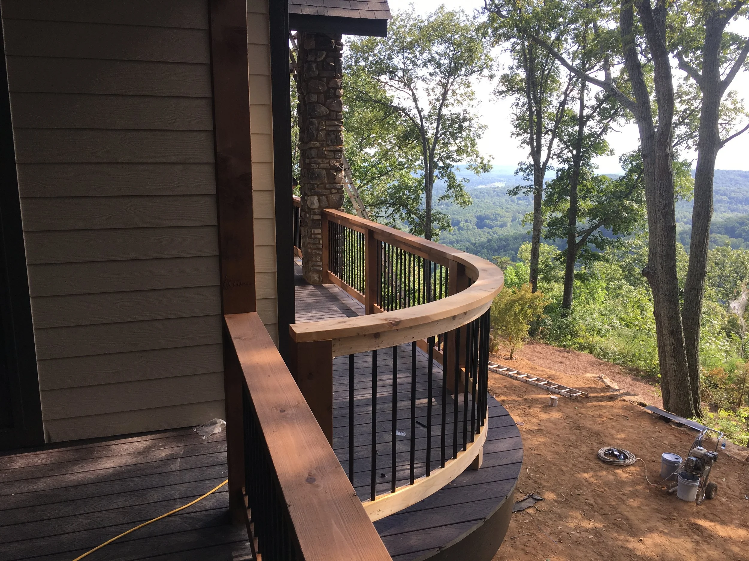 Trex Select composite decking with Trex Select skirt board. Cedar handrails with aluminum pickets on a curved walkway.