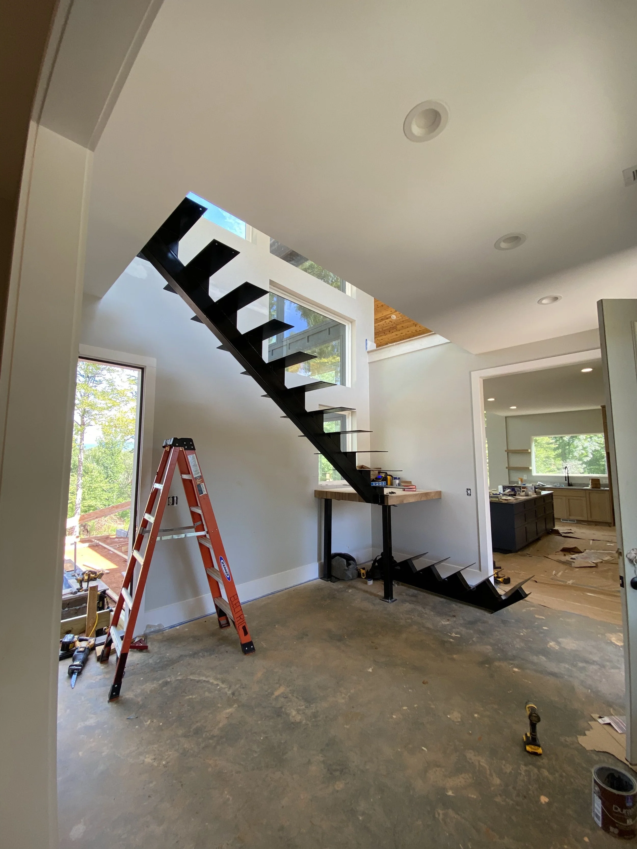 Custom welded steel beam stairs. 4"x12" solid oak treads and solid oak landing.