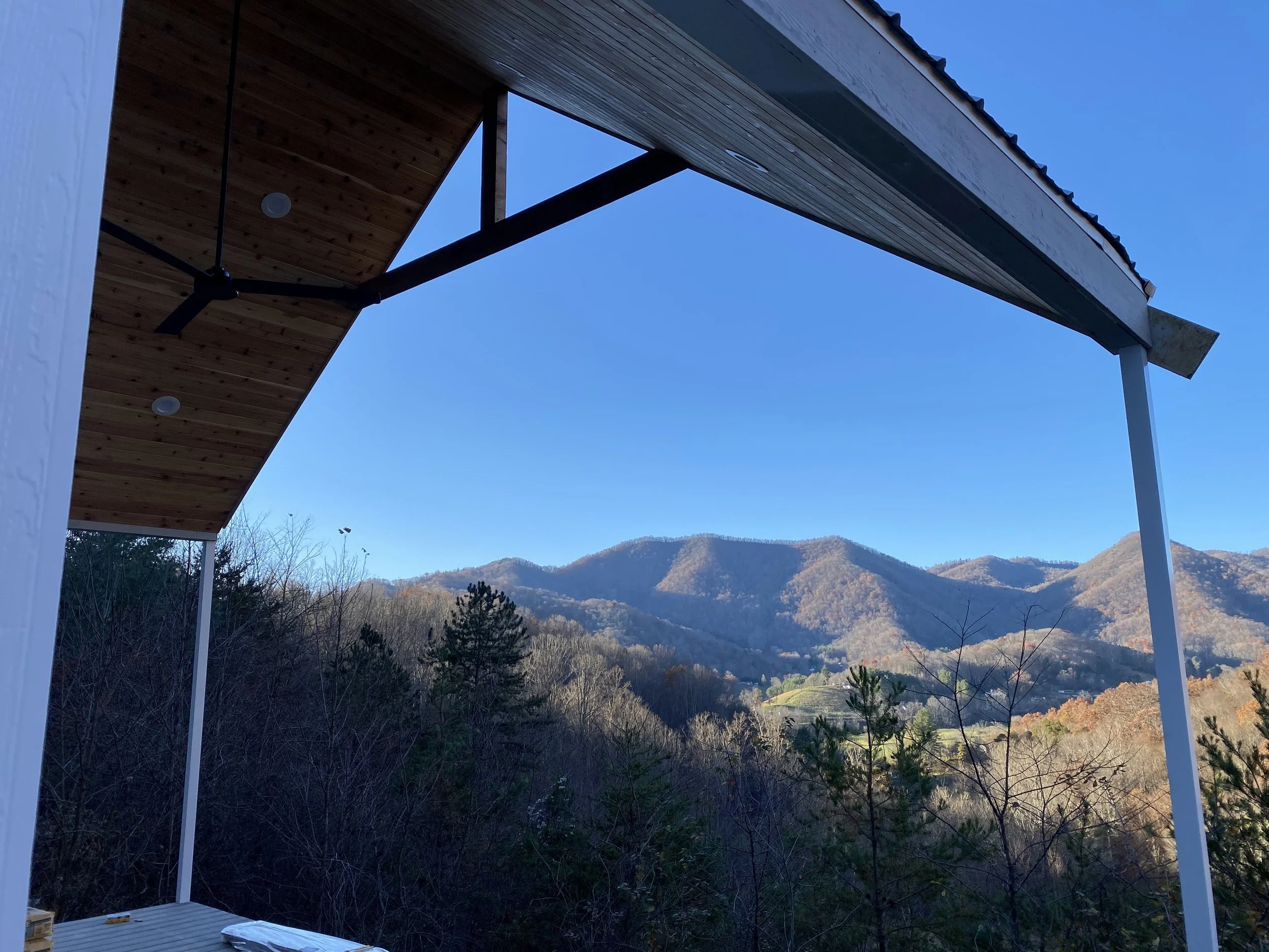 1x6 cedar tongue and groove board installed on front porch ceiling. Structural 4x6 cedar collar tie with king post. LED recessed can lights and ceiling fan. 3x3 extruded aluminum support posts under roof.