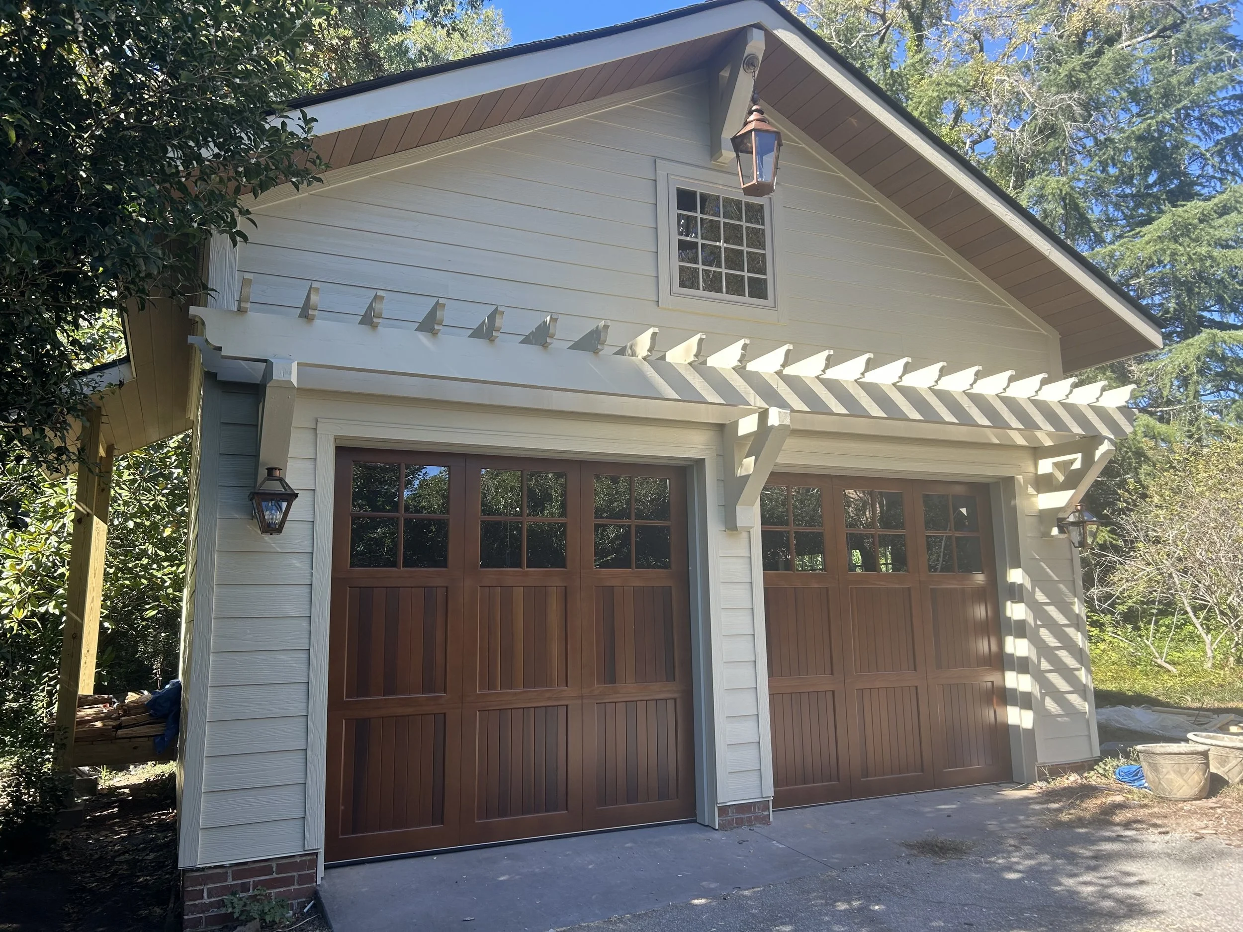 Detached two car garage with large attic storage above. Fiber cement siding with custom trellis above custom solid wood garage doors. Vinyl casement windows.