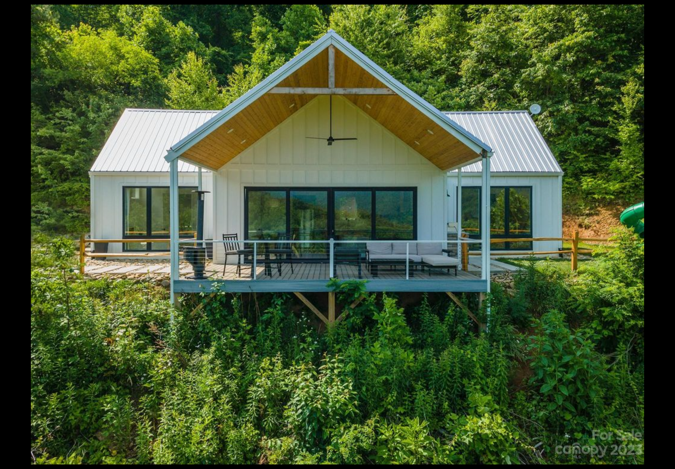 Finished front porch deck. Extruded aluminum handrail with cable railing. Trex Enhanced Naturals decking installed with Trex hidden fasteners. Board and baton fiber cement siding.
